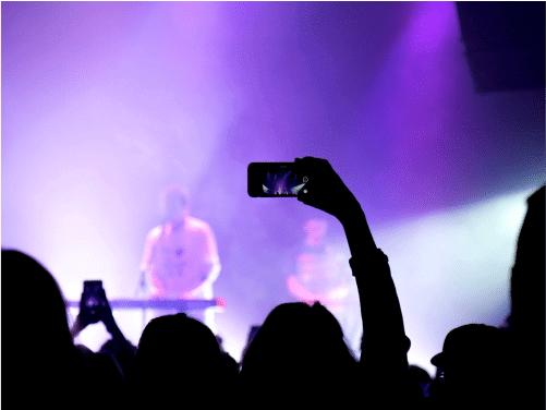 person holding phone at a concert