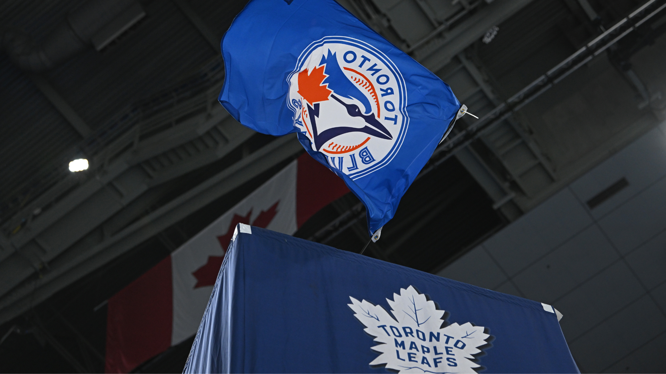 Toronto Blue Jays flag flying over top of the Maple Leafs flag during Maple Leafs home game.