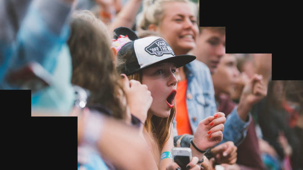 Image of a female music festival fan cheering in the crowd.